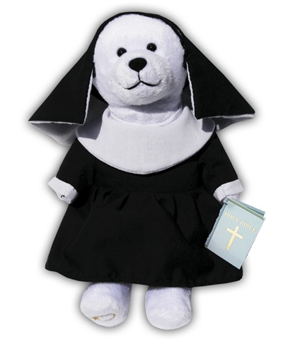 White plush bear wearing a black nun's habit and black veil. Bear is holding a blue Holy Bible.