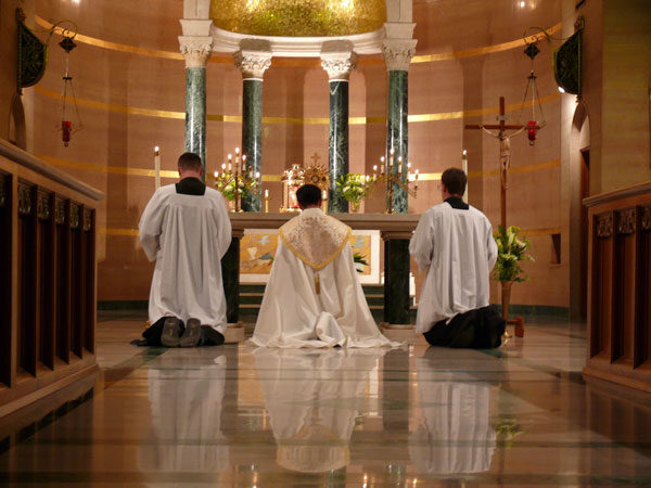 Priests kneeling at altar.