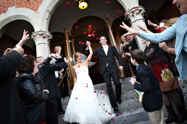 Bride and Groom walking out of the church showered with rose petals.