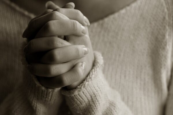 women's hands clasped in prayer.
