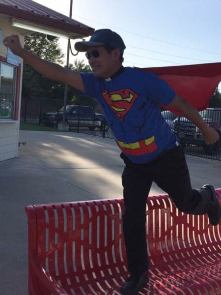 priest dresed in superman costume.